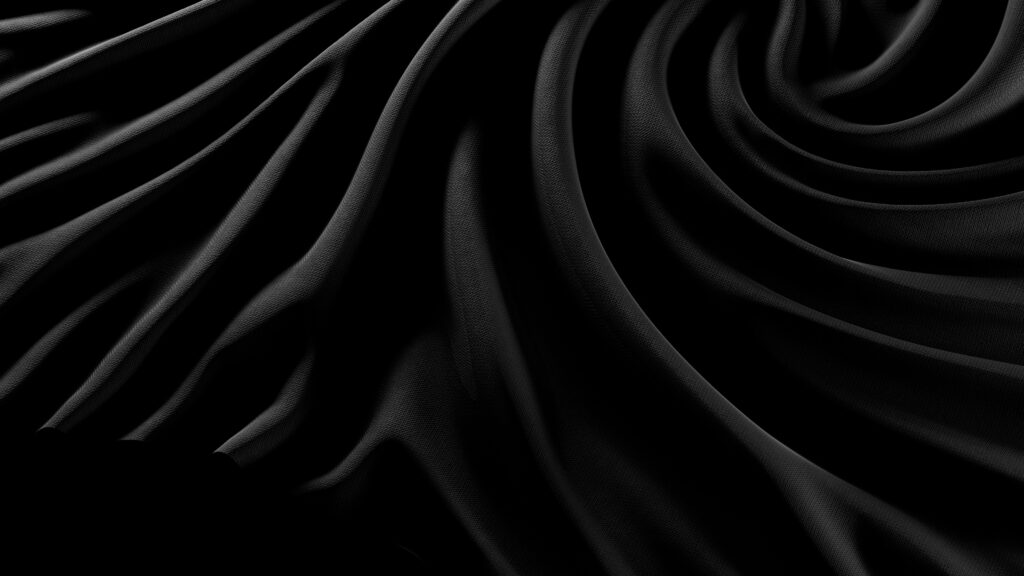 black satin sheets twisted and laid on a surface.