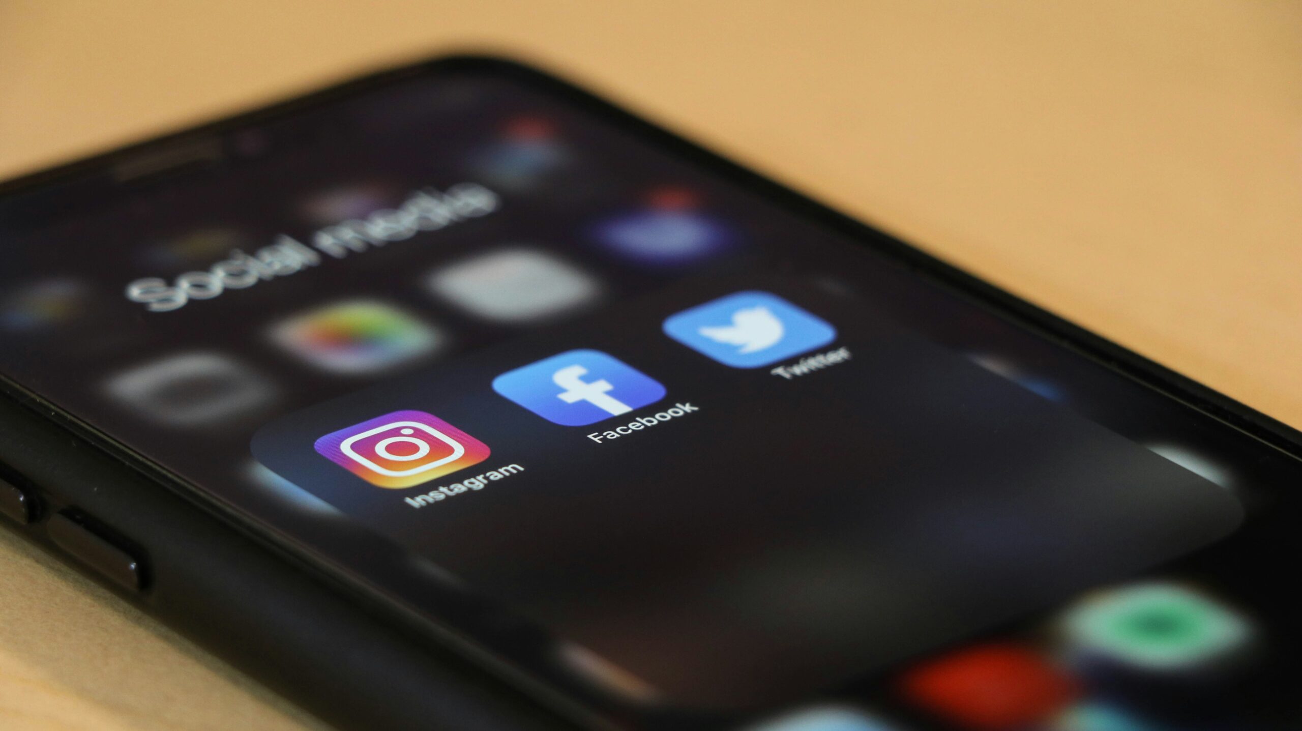 Smartphone screen displaying social media apps including Facebook, Instagram, TikTok, YouTube, LinkedIn, Pinterest, and Threads.